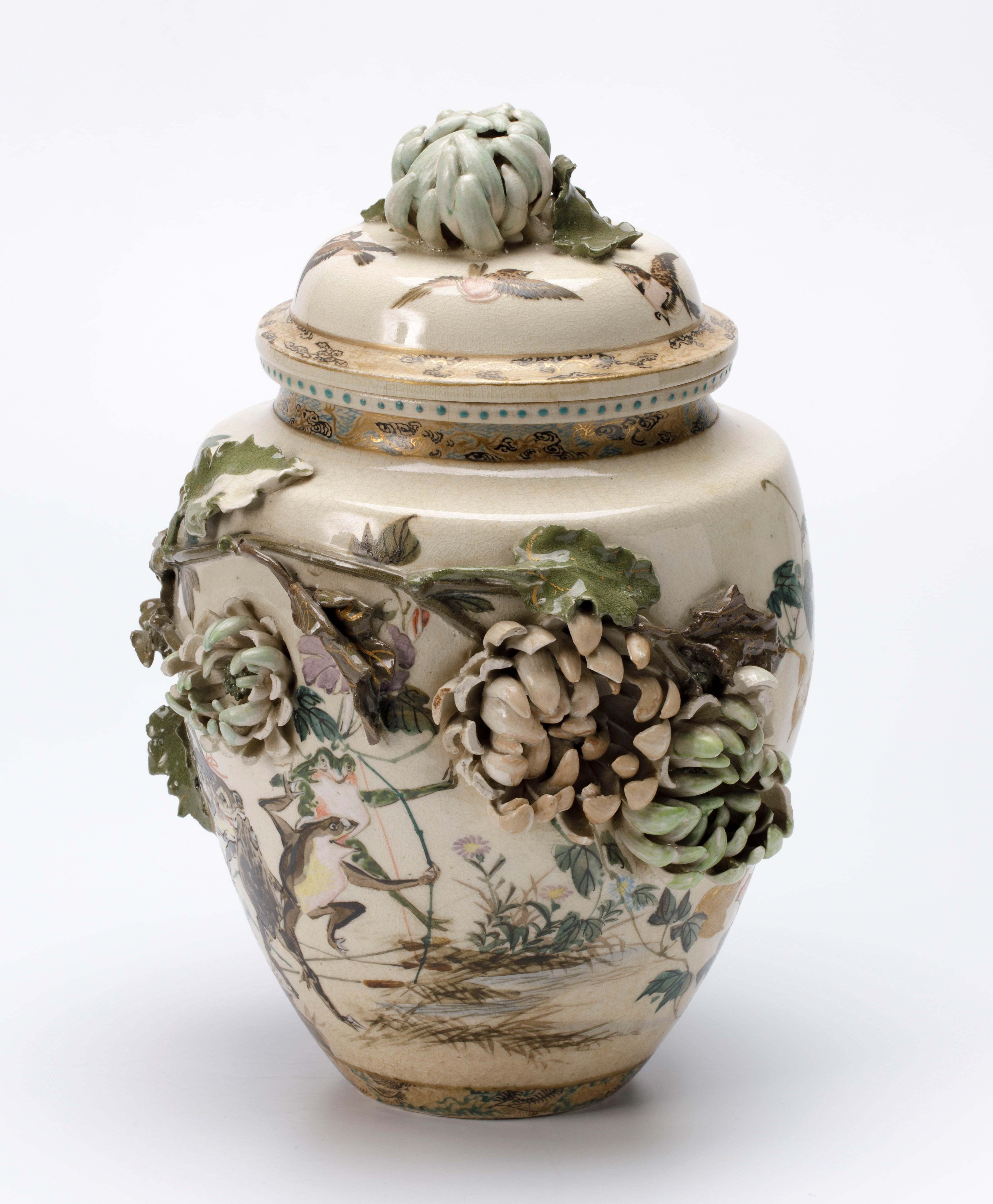 Covered vase decorated with dancing frogs in nanga style and chrysanthemum in relief, Japan, Meiji period (1868–1912), h. 31 x diam. 21 cm, stoneware with overglaze enamels and gilding, Wereldmuseum (purchased on 1 November, 1883), RV-420-26a.